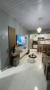 马卡帕Casa Moderna - Centro的客厅里有一张沙发，墙上有一台电视
