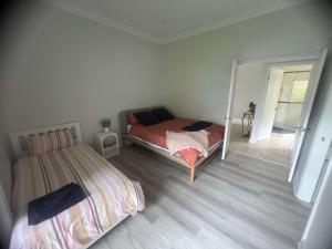 - une chambre avec 2 lits et une porte donnant sur un balcon dans l'établissement King Bed w Ensuite - Sleeps 8 - Lake Aquascape, à Neranwood 2 autres photos