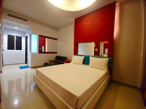 a bedroom with a large bed with a red headboard at Save Hotel เซฟ โฮเทล in Chon Buri