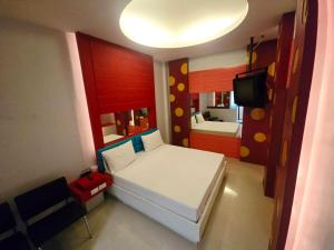 a small bedroom with a bed and a television at Save Hotel เซฟ โฮเทล 