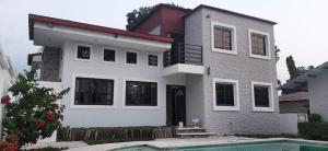 ein Haus mit einem Swimmingpool davor in der Unterkunft Villa Fluvia Rafaela in Retalhuleu