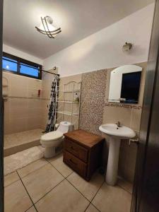 ein Badezimmer mit Toilette, Waschbecken und Badewanne in der Unterkunft Villa Fluvia Rafaela in Retalhuleu