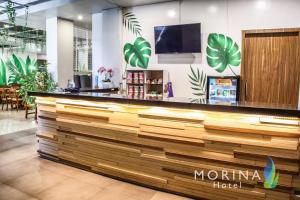 un mostrador en un restaurante con una gran pila de madera en Sunrise Hotel Malang, en Rampal