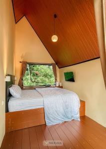 Un dormitorio con una cama grande con ventana. en The Kotenang, en Wonosobo