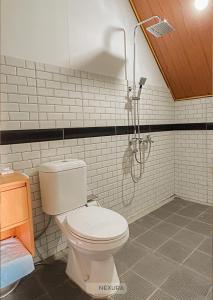 Un baño con inodoro y ducha en The Kotenang, en Wonosobo