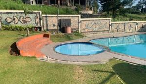 ein Schwimmbad mit einem Pfad um ihn herum in der Unterkunft Sentral Villa Trawas in Trawas + 7 Fotos