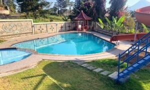 a pool in a yard with a gazebo at Sentral Villa Trawas in Trawas