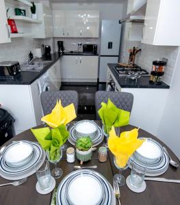 une cuisine avec une table avec des assiettes et des verres dessus dans l'établissement PG Stays - Spacious Rooms with Shared Facilities, à Wigan