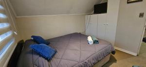a small bedroom with a bed with blue pillows at Buen descanso cómodo y acogedor en Machali con Parcking y WIFI in Machalí