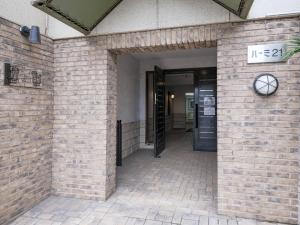 an entrance to a brick building with a sign on it at 泊るHouse千葉駅1分 J - 東京ディズニーランドまで30分 線路傍騒音あり in Chiba