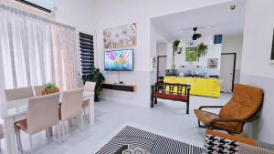 a living room with a table and chairs and a yellow cabinet at Homestay BAYT AL - JAZMY in Kuantan
