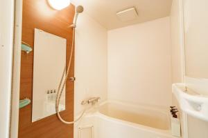 a white bathroom with a tub and a sink at Higashi-Shinjuku 906 in Tokyo +73 photos