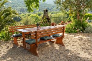 un banco de madera con una mesa en un jardín en Haus Gaia, en Rabac