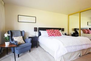 Un dormitorio con una cama grande y una silla azul. en Luxe Golf View Condo Prime Napa Location, en Vichy Springs