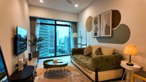 a living room with a couch and a large window at Eaton Residence Kuala Lumpur - M Home in Kuala Lumpur