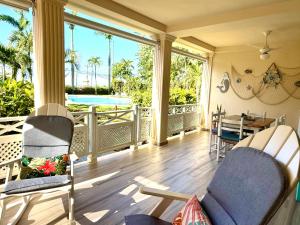 een afgeschermde veranda met een tafel en stoelen bij La Dolce Vita Beachfront Apt 2 in Las Terrenas