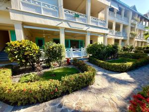 een appartementengebouw met een binnenplaats met bloemen en planten bij La Dolce Vita Beachfront Apt 2 in Las Terrenas