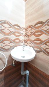 a white sink in a room with a wall at Varun Residency New in Coimbatore
