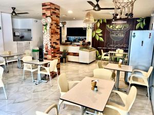 a restaurant with tables and chairs and a kitchen at Hotel Roma Urabá in Apartadó