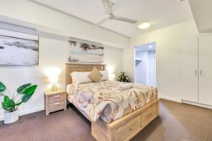 a bedroom with a large bed and a white wall at Luxury in Litchfield Street - Heart of the CBD in Darwin +28 photos