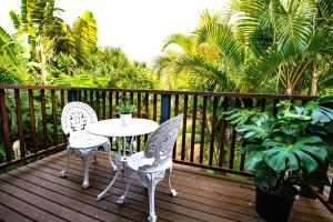 two chairs and a table on a wooden deck at Loft Apartment - 1 Bedroom in Brunswick Heads