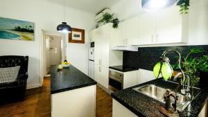 a kitchen with black counter tops and a sink at Loft Apartment - 1 Bedroom in Brunswick Heads