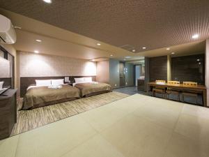 a large bedroom with a bed and a desk at 泊るHouse千葉駅1分 J - 東京ディズニーランドまで30分 線路傍騒音あり in Chiba