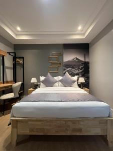 a bedroom with a large bed with a painting on the wall at Doña Manor Boutique Hotel in Olongapo +50 photos
