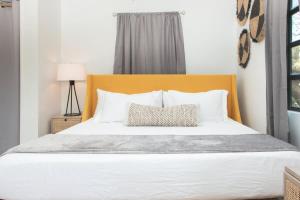 a bedroom with a white bed with a yellow headboard at Cruz Bay Oasis Walk to Beach & Stunning Views in Enighed +16 photos