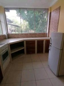 een keuken met een witte koelkast en een raam bij Emerald forest apartment in Iquitos