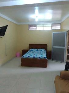 een slaapkamer met een bed in het midden van een kamer bij Emerald forest apartment in Iquitos