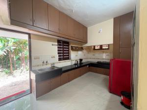 科钦Kochuthottathil Heritage的厨房配有棕色橱柜和红色冰箱