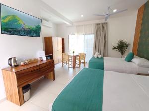 a hotel room with two beds and a desk at Punta Colibrí in Brisas de Zicatela