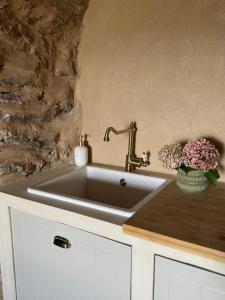 a sink in a kitchen with a stone wall at Village House With Character In Corsica in Scolca +10 photos