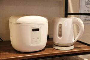 two white appliances sitting on a wooden shelf at Kamon Inn Uji 2-D in Uji +15 photos