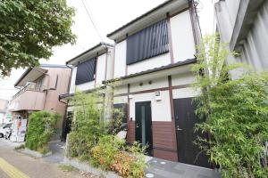 a house with a black and white at Kamon Inn Uji 2-D in Uji