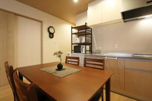 a kitchen with a table with a vase on it at Kamon Inn Uji 2-D in Uji