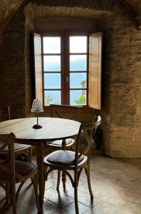 a table and chairs in a room with a window at Village House With Character In Corsica in Scolca
