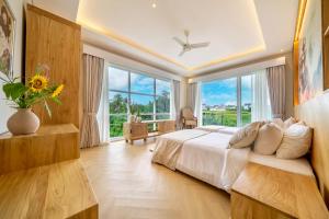 Tumbak Bayuh4Br Brand New Canggu Modern Villa的一间卧室，里面有一张床和一扇大窗户。 更多65张照片