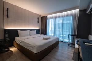 a bedroom with a large bed and a large window at Bayphere Residence by Prop Hopper in Na Jomtien