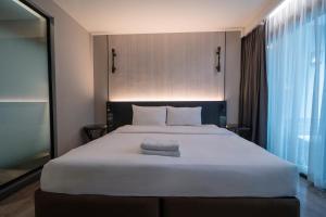 a large white bed in a room with a window at Bayphere Residence by Prop Hopper in Na Jomtien +26 photos