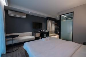a bedroom with a white bed and a bathroom at Bayphere Residence by Prop Hopper in Na Jomtien