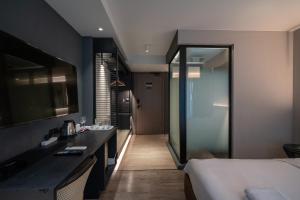 a hotel room with a bed and a bathroom at Bayphere Residence by Prop Hopper in Na Jomtien