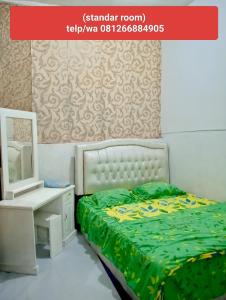 ブキティンギにあるHotel Marinetのベッドとドレッサーと鏡のある寝室