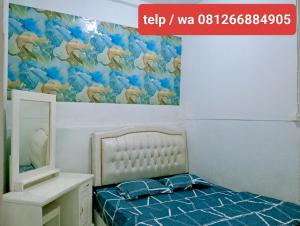 ブキティンギにあるHotel Marinetのベッドと壁画のある寝室 +3枚の写真