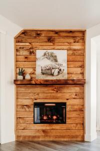 a wooden fireplace in a living room with a picture at Happy Trails BnB in Tropic +60 photos