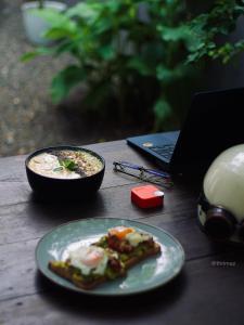 a table with a plate of food and a laptop at Cozy Space - Madiha in Matara
