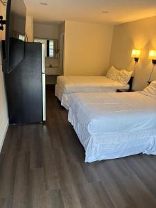 two beds in a hotel room with wood floors at Suite Stay in Talladega