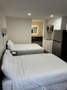 a hotel room with two beds and a refrigerator at Suite Stay in Talladega