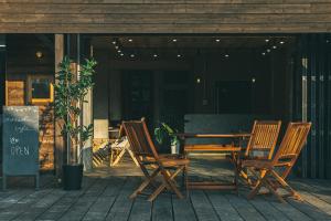 a wooden table and chairs on a patio at のあそびlodge in Arao